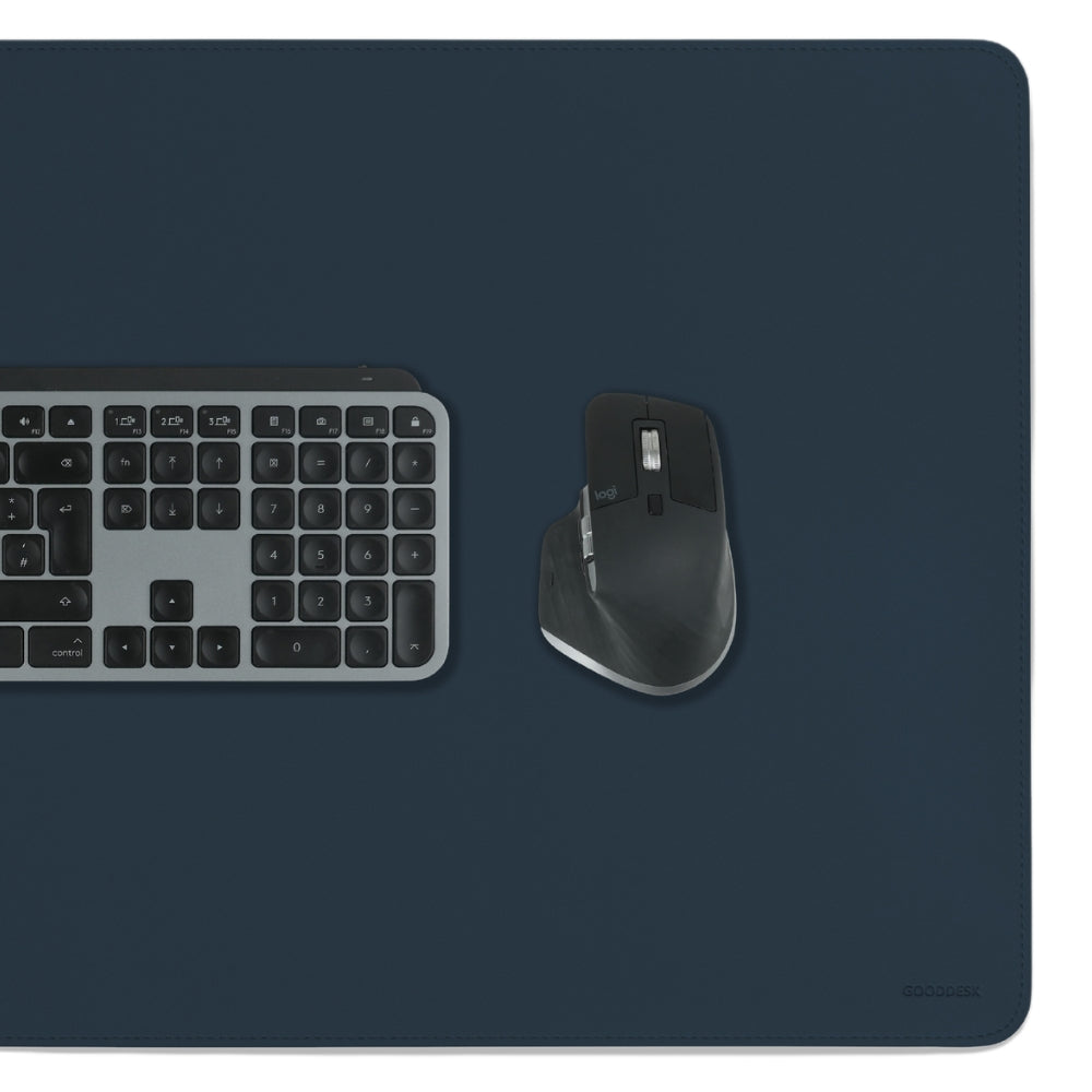 Dunkelblaue MATDESK Schreibtischunterlage aus Premium-Kunstleder mit einer Tastatur und Maus darauf platziert. Die elegante, rutschfeste Unterlage bietet eine hochwertige und komfortable Arbeitsfläche.